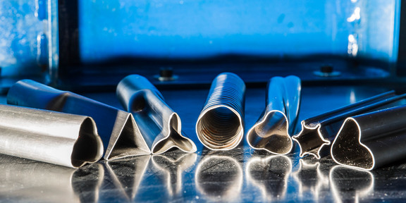 Maschinenbau_06 Verschieden große Metallrohe liegen nebeneinander.